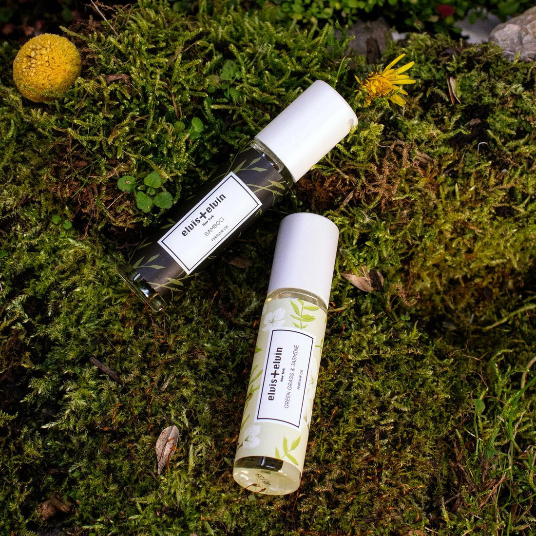 Two perfume bottles on the natural grass.